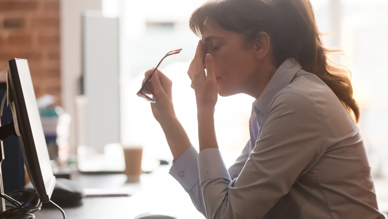 Exhausted female worker sit at office desk take off glasses feel unwell having dizziness or blurry vision, tired woman employee suffer from migraine or headache unable to work. Health problem concept; Shutterstock ID 1489697975