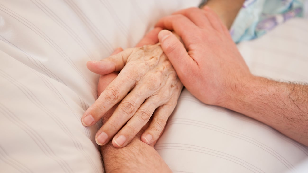 Holding hands of a patient in hospital and deathbed; Shutterstock ID 1614946072