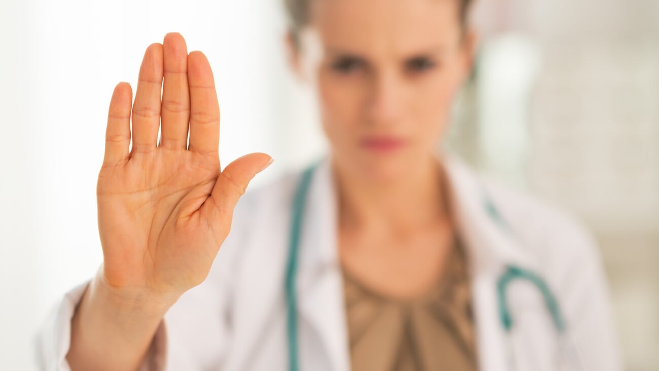 Closeup on serious medical doctor woman showing stop gesture; Shutterstock ID 196230803