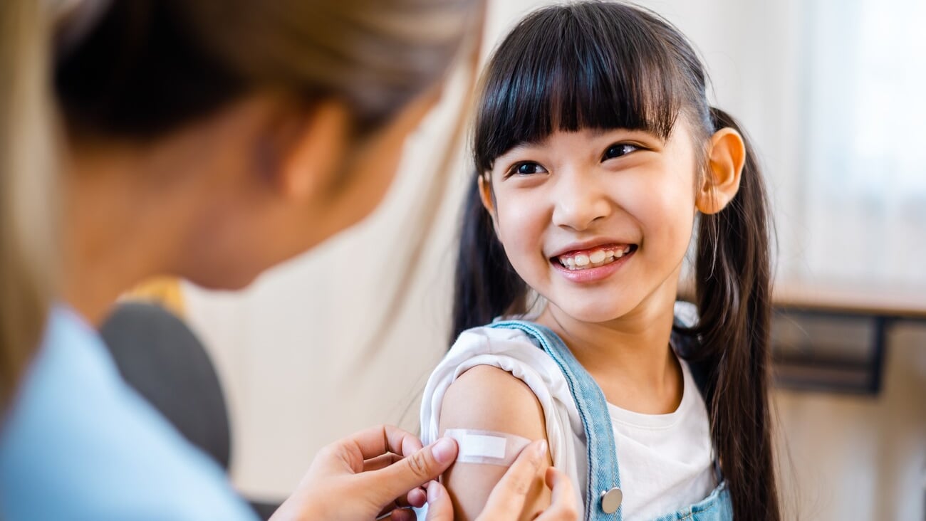 Childhood vaccination. Asian young woman doctor vaccinating little girl at home. Vaccine for covid-19 coronavirus, flu, infectious diseases.; Shutterstock ID 2147986397