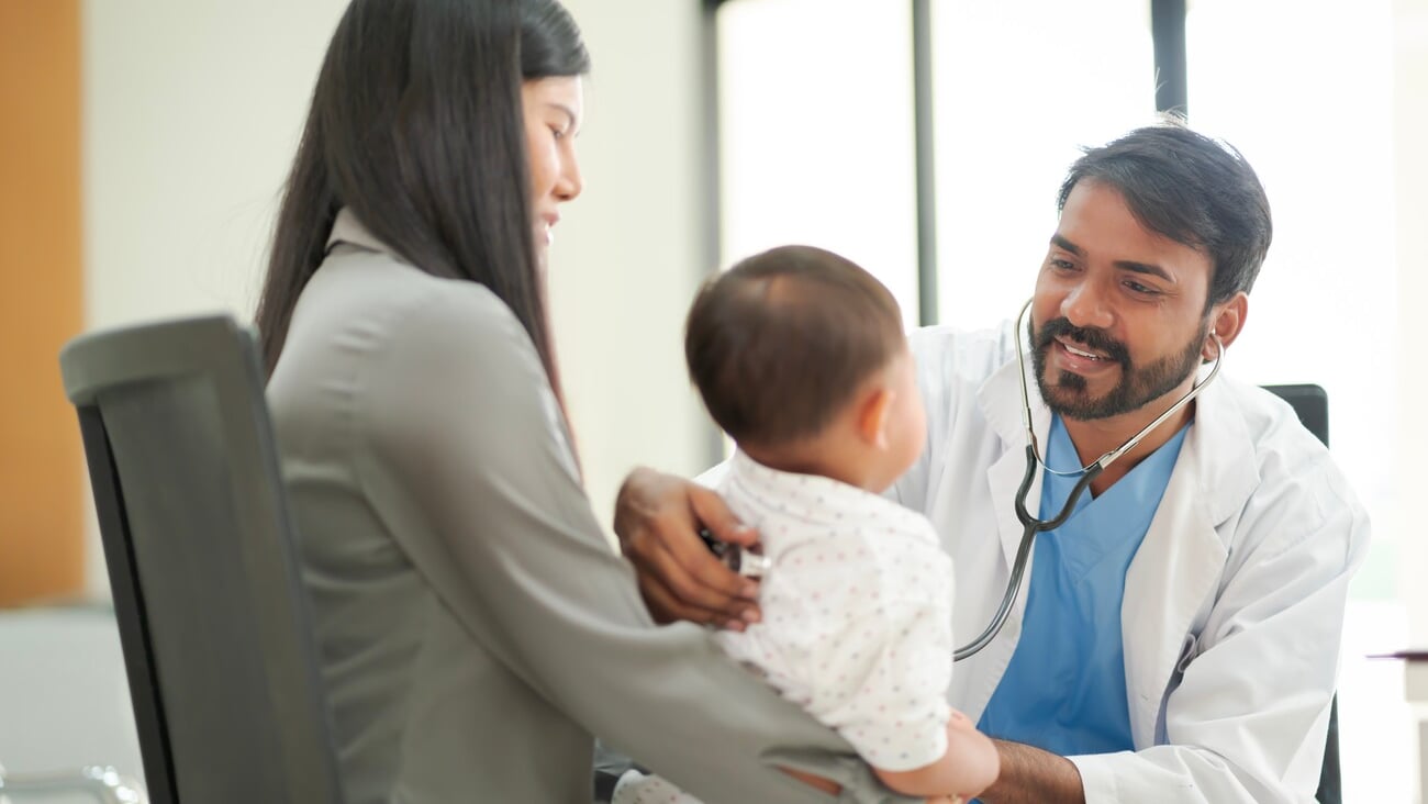 A kind doctor who treats pediatric patients. The child and his family brought him to see the doctor at the hospital because he was ill.; Shutterstock ID 2268919809