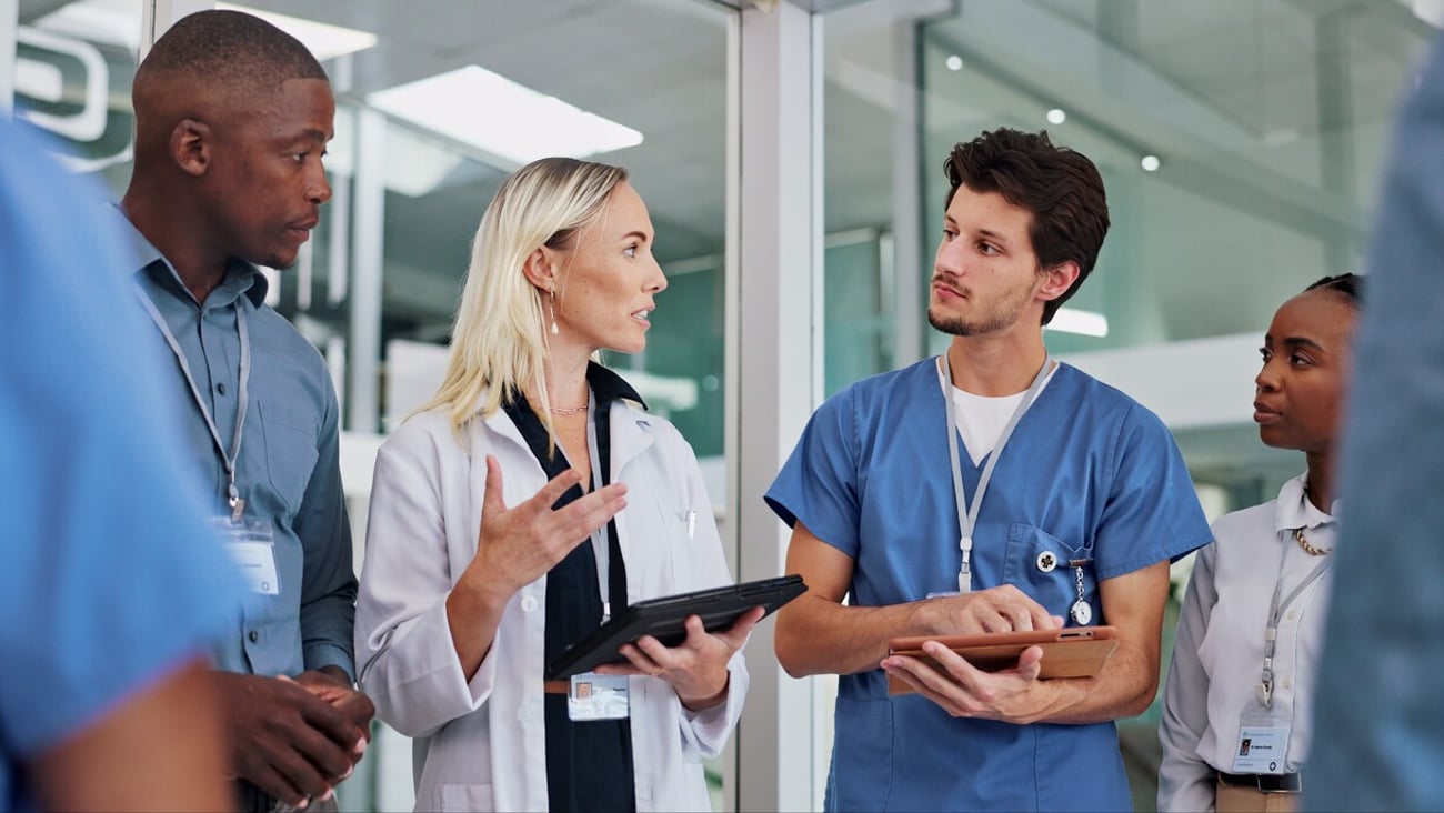 Doctors, group and meeting on tablet for medical planning, advice and support in teamwork or hospital solution. Healthcare staff, people and leader on digital technology and talking of clinic results; Shutterstock ID 2449222117