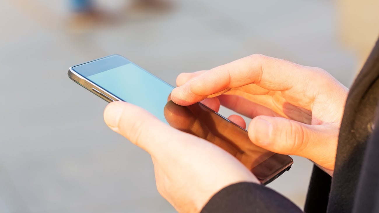Close up of hands man using cell phone, outdoor; Shutterstock ID 329288636