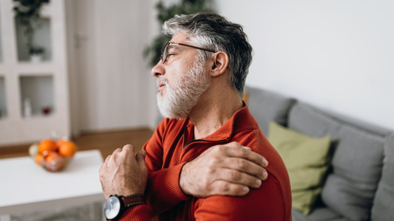 Un homme souffre de sa douleur à l'épaule.