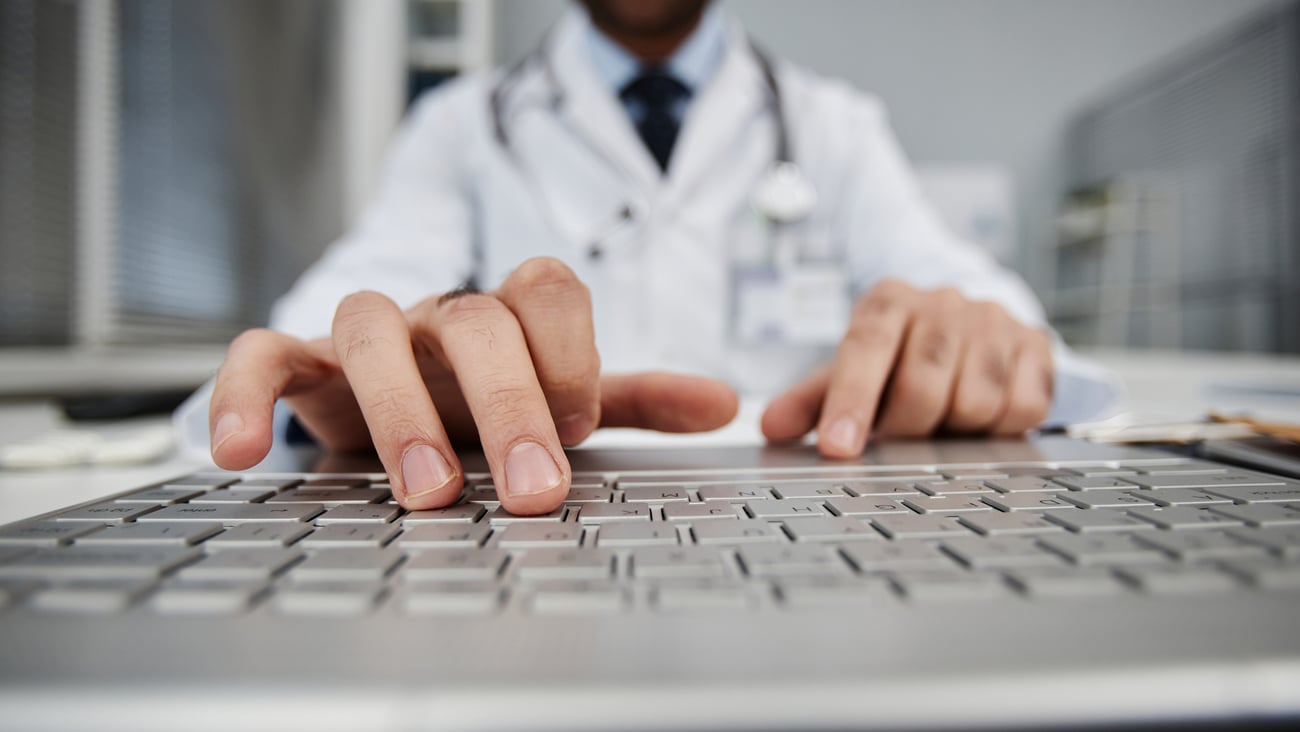 Doigts d'un médecin sur le clavier d'un ordinateur