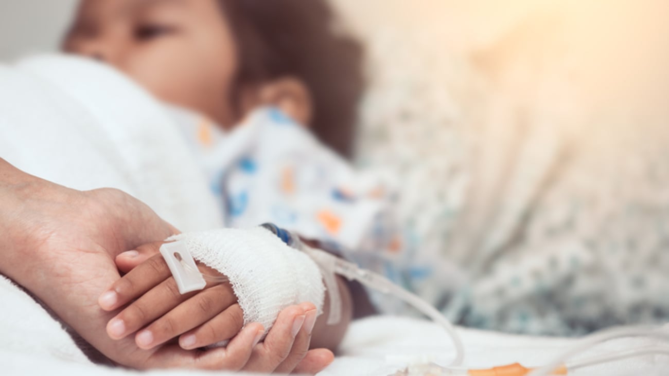 Un enfant est hospitalisé, avec un soluté.