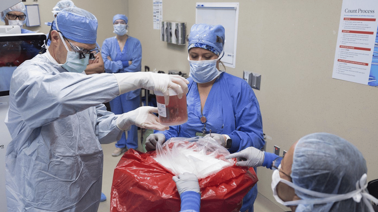 Le docteur David Lott, responsable de la chirurgie de la tête et du cou, sort l'organe d'un donneur d'un conteneur de perfusion à l'hôpital de la Clinique Mayo.(Mayo Clinic via AP)