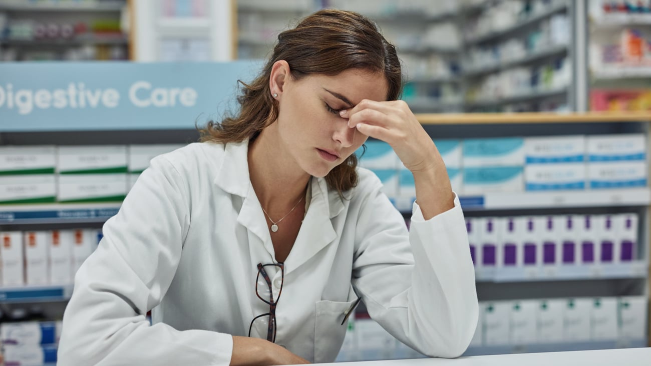 Une pharmacienne stressée réfléchit. 