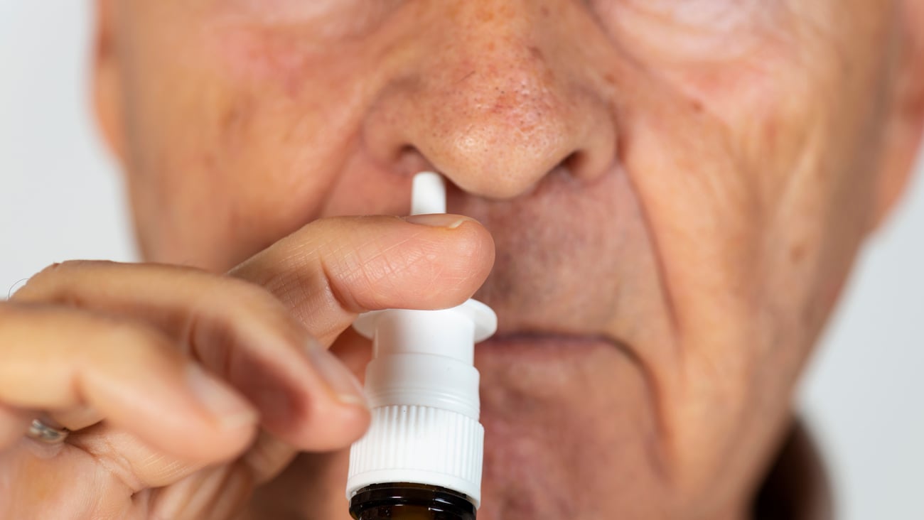 Un homme fait usage d'un vaporisateur nasal.