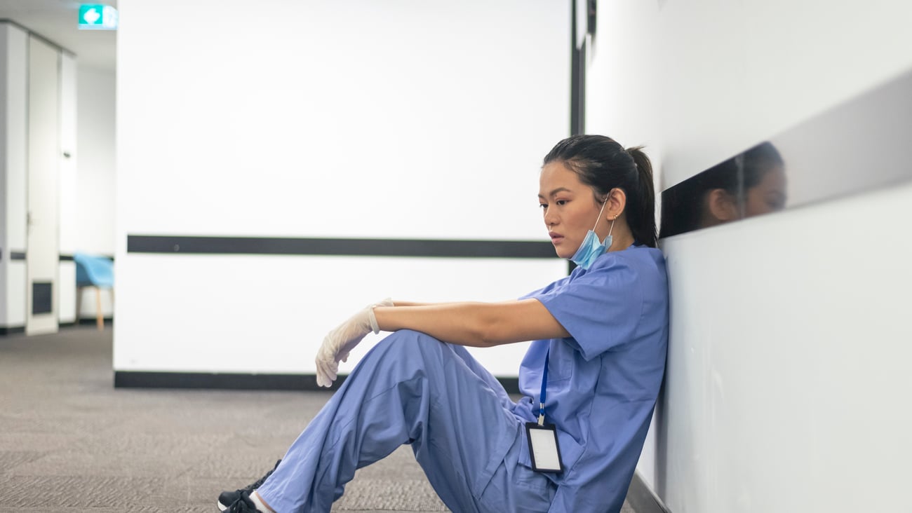 Jeune chirurgienne assise dans le couloir d'un hôpital