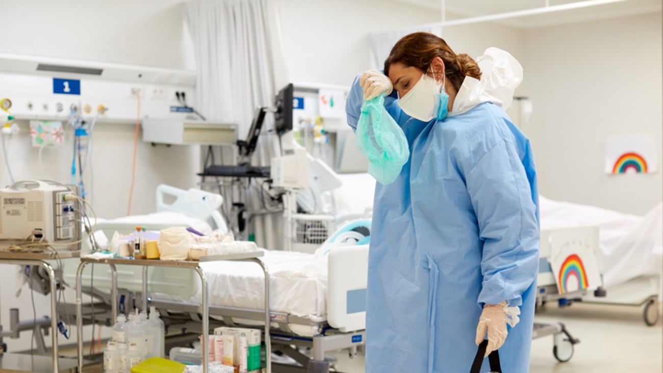 Une médecin s'essuie le front après une longue journée durant la pandémie.