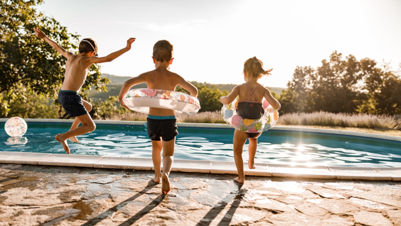 Des enfants sautent dans une piscine.