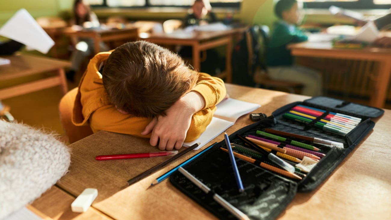 Un enfant dort en classe, à l'école.