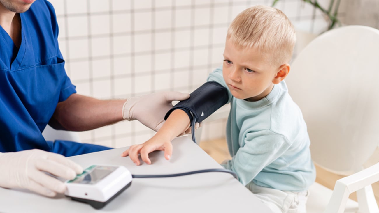 Un professinnel de la santé mesure la tension artérielle d'un enfant.