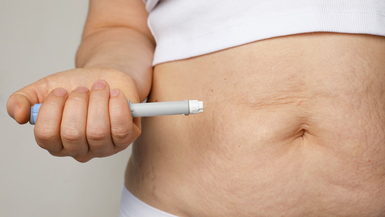 Female belly and hand closeup with Semaglutide Injection pen or insulin cartridge pen. Medical equipment for diabetes patient. Diabetes and weight loss concept. ; Shutterstock ID 2421756967