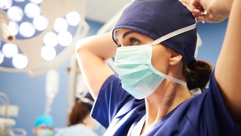 une chirurgienne met son masque avant de procéder à une opération