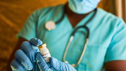 un médecin tient un flacon de vaccin contre la Covid