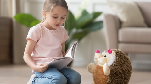 Une fillette fait la lecture à son toutou.