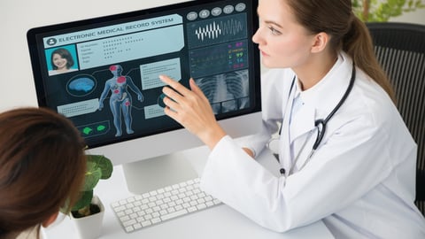 Une médecin et son patient devant un écran d'ordinateur.
