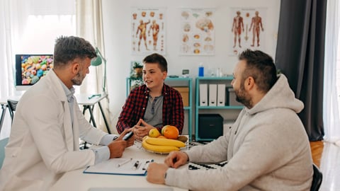 Un enfant discute avec un médecin de ses comportements face à la nourriture.