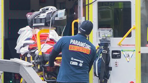 Des ambulanciers sortent un patient de l'ambulance.