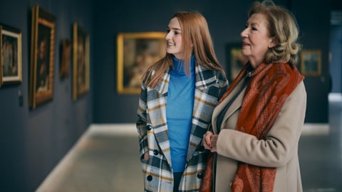 Une grand-mère et sa petite-fille en visite dans un musée.