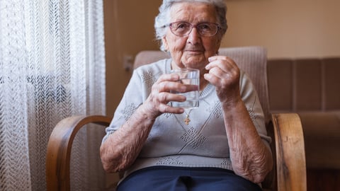 Une femme âgée prend un médicament