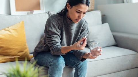 Une jeune femme prend un médicament