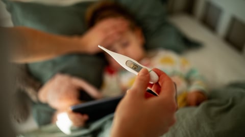 Une mère vient de prendre la température de son enfant qui a de la fièvre.