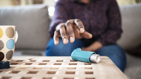 Une personne tend la main pour aller saisir sa pompe pour son asthme.