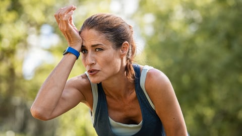 Une femme dana la quarantaine qui fait son jogging est essouflée.