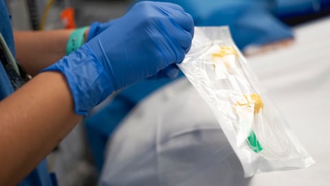 Une infirmière ouvre un emballage stérile contenant un cathéter IV en milieu hospitalier.