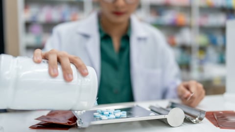 Une pharmacienne manipule des médicaments dans un laboratoire.