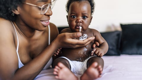 Une mère est à côté de son bébé qui vient de régurgiter.