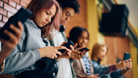 Des adolescents utilisent leurs téléphones portables pour aller sur les médias sociaux