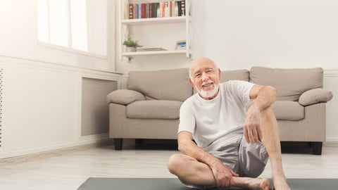 Un homme âgé est assis par terre, en train de se relever.