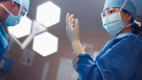 Une femme chirurgienne met ses gants