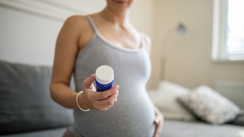 Une femme enceinte tient une boîte de médicaments