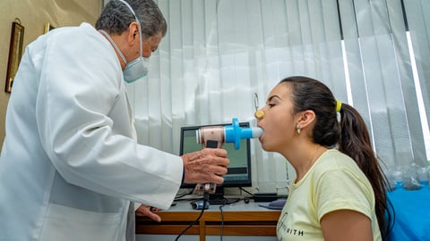Une jeune femme passe un test de spirométrie dans le cabinet d'un médecin.