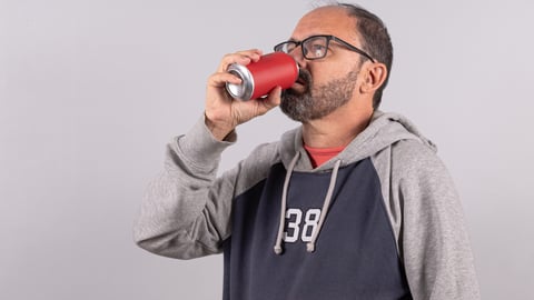 Chauve en train de boire un coke