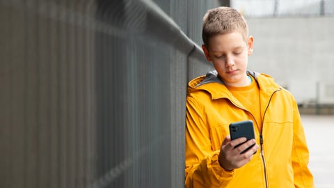 Un jeune adolescent consulte son smartphone