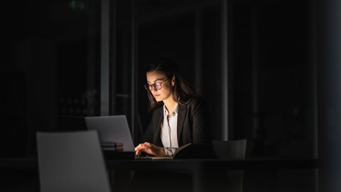 Une femme travaille dans un bureau, la nuit.