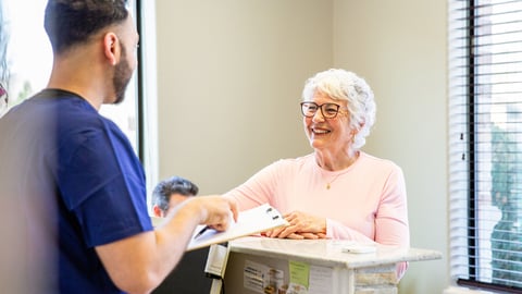 Une patiente discute avec un soignant à l'accueil d'une clinique privée