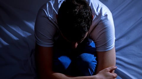 Homme assis éveillé dans son lit