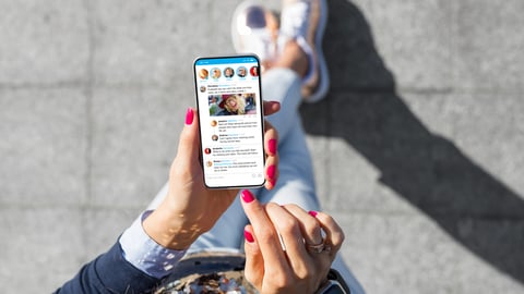 Une femme utilise son téléphone pour consulter des réseaux sociaux.