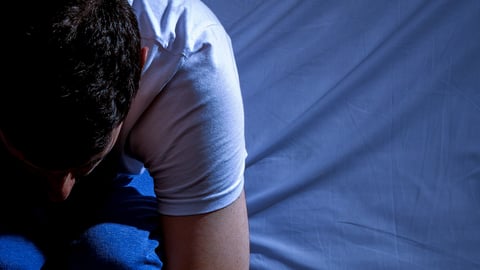 Homme assis éveillé dans son lit