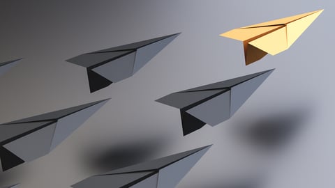 Avion de papier doré suivi de plusieurs autres avions de papier gris