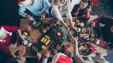 Une famille partage un repas des Fêtes. Crédit photo: Deagreez/ Getty Images