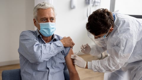 Un homme se fait vacciner contre la COVID-19. Crédit photo: andresr/ Getty Images