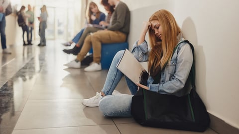 Adolescente triste dans un couloir de son école. Crédit photo: skynesher/ Getty Images